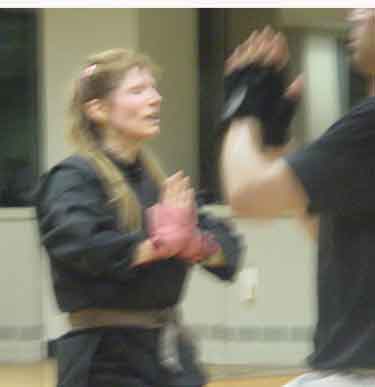 ALT =[“Dr. Jolie Bookspan: 4th degree black belt in Shotokan Karate, Undefeated full-contact Muay Thai fighter, International Black Belt Hall of Fame, Instructor Rank of Master.”] 